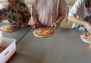 Dzieci przygotowujące pizze.