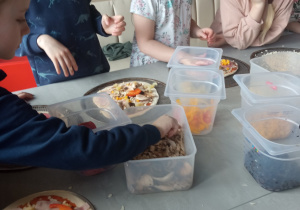 Dzieci przygotowujące pizze.