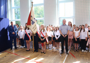 Nauczyciele i uczniowie w czasie uroczystości na sali gimnastycznej