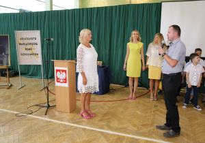 Nauczyciele i uczniowie w czasie uroczystości na sali gimnastycznej