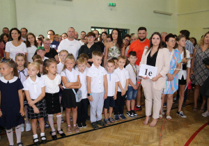 Nauczyciele i uczniowie w czasie uroczystości na sali gimnastycznej