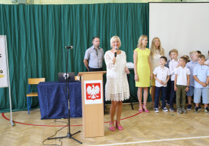 Nauczyciele i uczniowie w czasie uroczystości na sali gimnastycznej