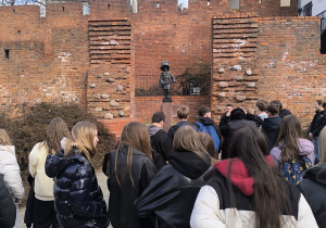 Grupa uczniów na tle pomnika