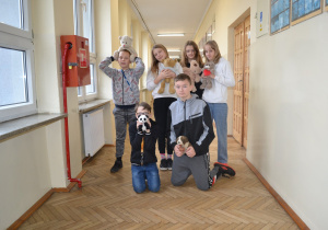 Uczniowie z pluszowymi maskotkami.