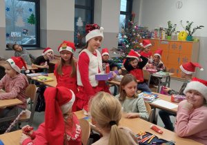 Uczniowie w świątecznych przebraniach w sali klasowej