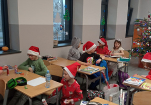 Uczniowie w świątecznych przebraniach w sali klasowej
