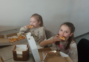 Dzieci jedzące pizze.