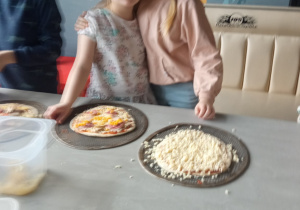 Dzieci przygotowujące pizze.