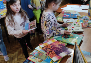 Dzieci oglądające książki w bibliotece szkolnej