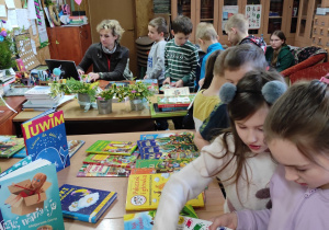 Dzieci oglądające książki w bibliotece szkolnej