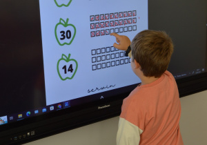 Uczeń przy monitorze multimedialnym