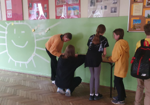 Uczniowie dekorujący ścianą na korytarzu