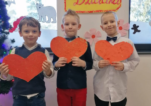 Dzieci trzymające serca wycięte z papieru