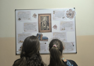 Dzieci oglądające gazetkę na tablicy korkowej