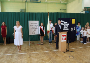 Uczniowie i nauczyciele w czasie uroczystości na sali gimnastycznej