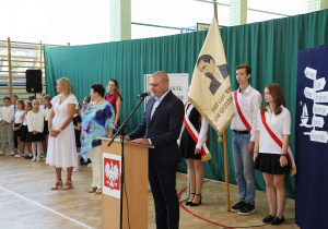 Uczniowie i nauczyciele w czasie uroczystości na sali gimnastycznej