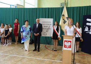 Uczniowie i nauczyciele w czasie uroczystości na sali gimnastycznej