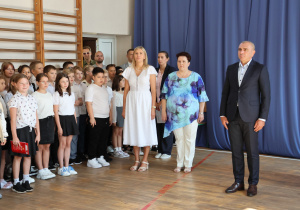Uczniowie i nauczyciele w czasie uroczystości na sali gimnastycznej