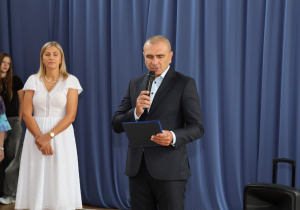 Uczniowie i nauczyciele w czasie uroczystości na sali gimnastycznej