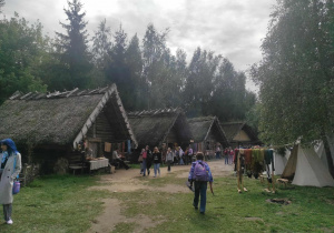 Uczniowie między chatami w Biskupinie