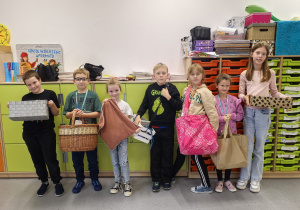 Grupa uczniów z dziwnymi "plecakami"