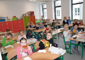 Uczniowie jedzący pizze.