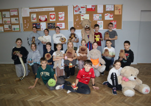 Grupa uczniów ze swoimi maskotkami.