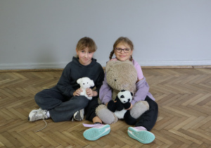 Grupa uczniów ze swoimi maskotkami.