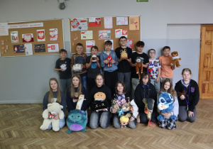 Grupa uczniów ze swoimi maskotkami.