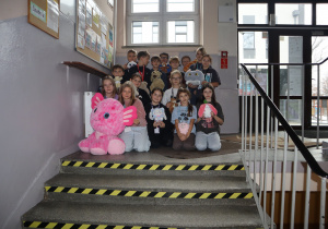 Grupa uczniów ze swoimi maskotkami.