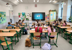 Uczniowie oglądający film w sali