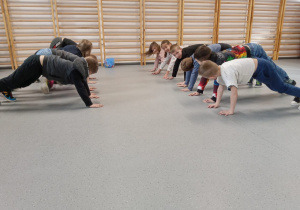 Uczniowie ćwiczący na sali gimnastycznej