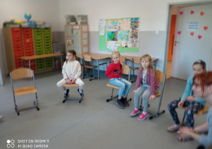 Dzieci siedzące na krzesłach