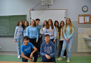 Grupa uczniów ubranych w niebieskie stroje.