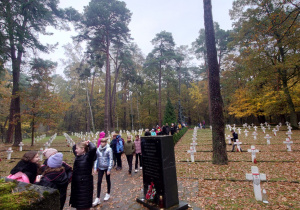 Uczniowie i opiekunowie na cmentarzu