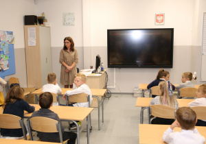 Uczniowie i nauczyciel na sali lekcyjnej